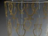 a clear glass with gold designs on it