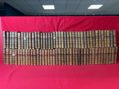 une grande pile de vieux livres posée sur un tissu rouge