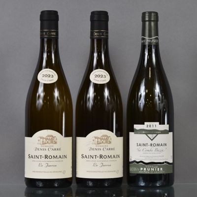 three bottles of wine are lined up on a glass table