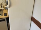 a white refrigerator in a kitchen with a microwave on top of it