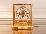 une horloge dorée posée sur une table en verre
