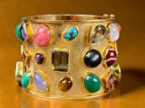gold cuff bracelet with multi colored stones and stones on it