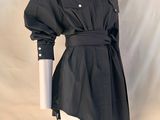 un mannequin portant une robe-chemise noire avec une ceinture