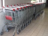 row of shopping carts lined up against a wall in a store