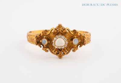 a close up of a gold ring with a white stone in the center