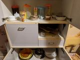 une petite cuisine dont les étagères sont encombrées