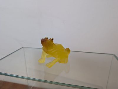 une table en verre sur laquelle se trouve une figurine de grenouille jaune