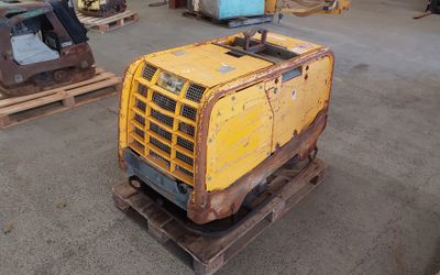 une petite machine jaune posée sur une palette dans un entrepôt