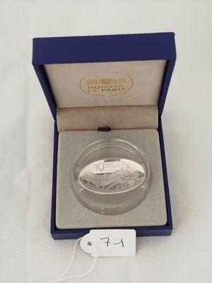 a silver coin in a blue box on a white surface