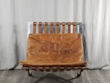 a brown leather chair sitting in front of a white curtain