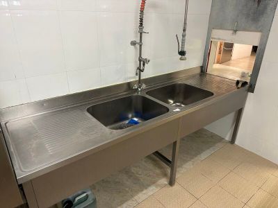 un lavabo en acier inoxydable dans des toilettes publiques