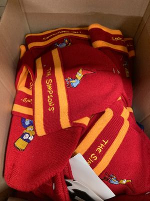 une boîte contenant un t-shirt rouge et une écharpe jaune et rouge
