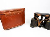 two old binoculars sitting next to each other on a white surface