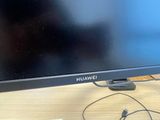 a computer monitor sitting on a desk with a charger plugged into it