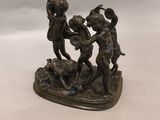 statue en bronze représentant trois enfants jouant avec un ballon sur une table