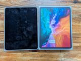 a close up of two ipads sitting side by side on a wooden surface