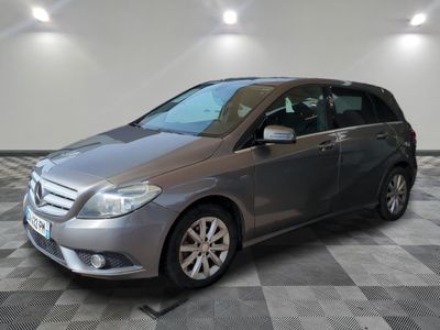 the mercedes b - class is parked in a garage with a checkered floor