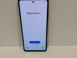 a close up of a cell phone on a table with a sign that says bienvenue