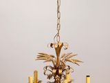 an antique brass chandelier with five candles and a bird on it
