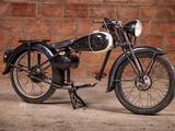 a black motorcycle that is parked in front of a brick wall