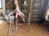 a small doll riding a bicycle in a room