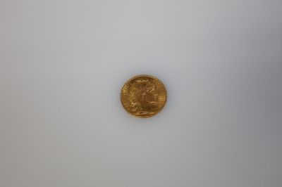 gros plan d'une pièce d'or sur une surface blanche