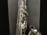 a close up of a saxophone on a stand on a black background