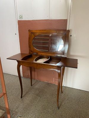 une petite table en bois sur laquelle se trouve un miroir