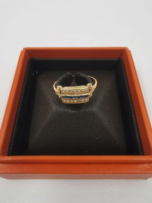 une image représentant une bague dans un écrin posé sur une surface blanche