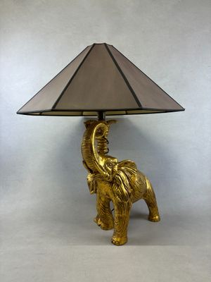 une lampe éléphant dorée avec un abat-jour sur le dessus