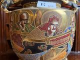 a gold bowl with a painting on it sitting on a table