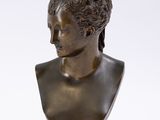 bronze bust of a woman on a pedestal on a white background