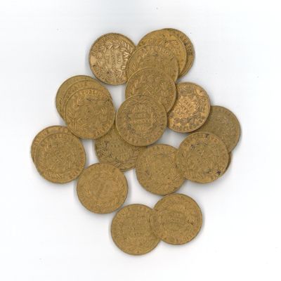 quelques pièces d'or posées sur une surface blanche, sur fond blanc