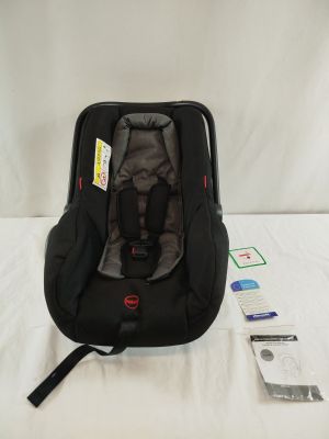 un siège auto pour bébé posé sur un lit