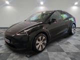 La Tesla Model Y est garée sur un sol en carrelage à damier.
