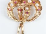 une image représentant une broche en or ornée de perles et de pierres roses