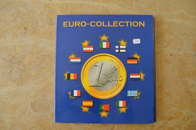 un gros plan d'un livre posé sur une table, avec une pièce d'un euro à côté