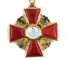 a red and gold medal with a cross on it