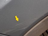 a yellow arrow on the hood of a gray car