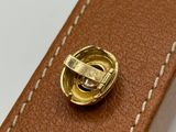 leather belt with a brass buckle on a white surface