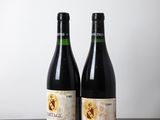 two bottles of wine sitting on top of a wooden table