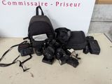 plein d'appareils photo et un sac à dos posés par terre