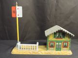 a small toy house with a street sign on the side of it