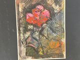 painting of a red rose in a black frame on a table