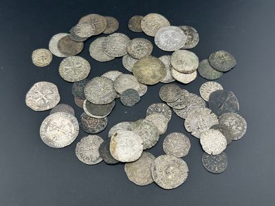 un tas de vieilles pièces d'argent posées sur une surface noire