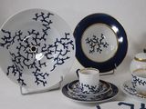 a white table with a blue and white plate and a tea set