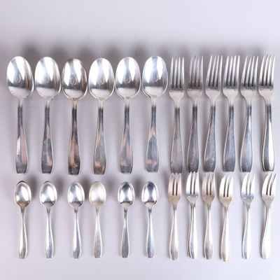 a lot of silver spoons and forks on the table