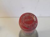 a small bottle with a red cap sitting on a table