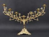 an ornate brass candelab with five candles on a stand