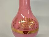 a pink glass vase with a gold decoration on it